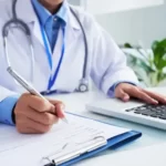 maos da medica irreconhecivel escrevendo no formulario e digitando no teclado do laptop 1098 20374